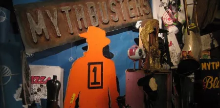 Ausschnitt aus der Serie Mythbusters mit allerlei Krimskrams um das Logo herum.