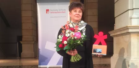Rena Tangens mit einem Blumenstrauß und dem Verbraucherschutzpreis.