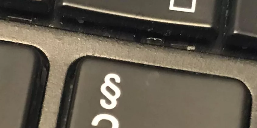 Detailaufnahme einer Tastatur mit dem Paragraphen-Symbol.