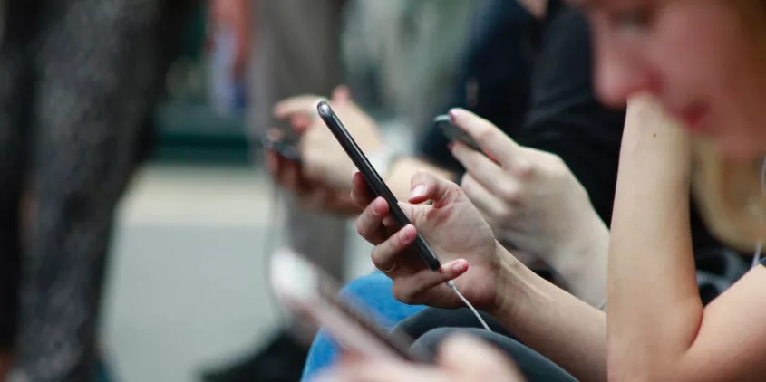 Detailaufnahme eines Smartphones, welches in einer Hand gehalten wird.
