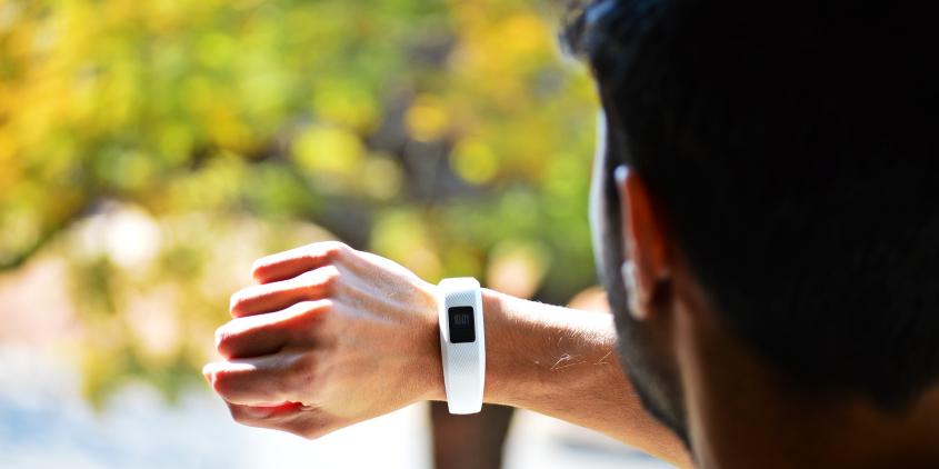 Mann schaut auf Fitbit-Uhr