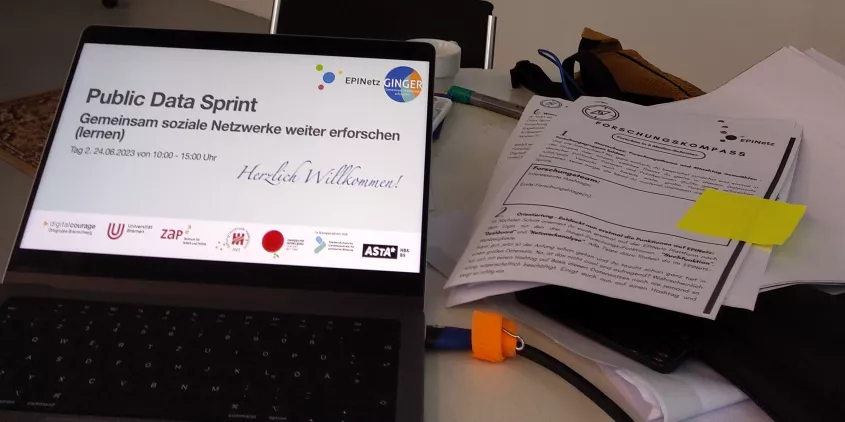 Foto vom Display eines Laptops mit einer Begrüßungsfolie mit der Überschrift "Public Data Sprint, Gemeinsam soziale Netzwerke weiter erforschen"