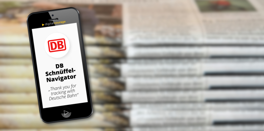 Grafik eines Smartphones mit der App „DB Schnüffel-Navigor“. Im Hintergrund ein Stapel Zeitungen.