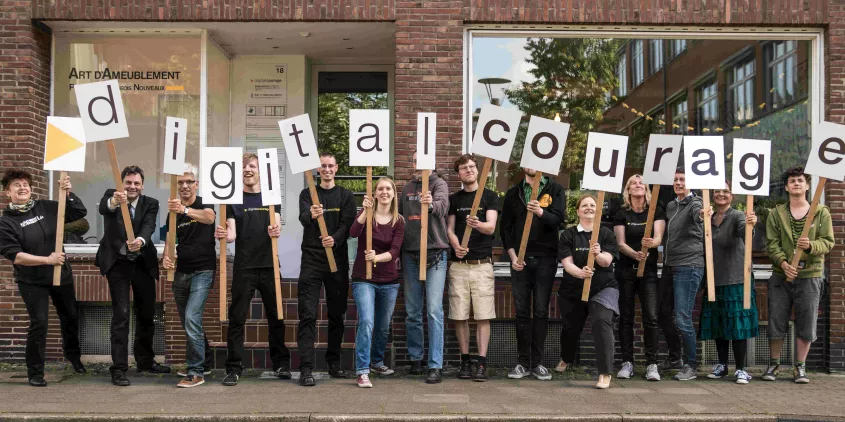 Das Team von Digitalcourage mit Schildern in der Hand, die das Wort Digitalcourage abbilden.