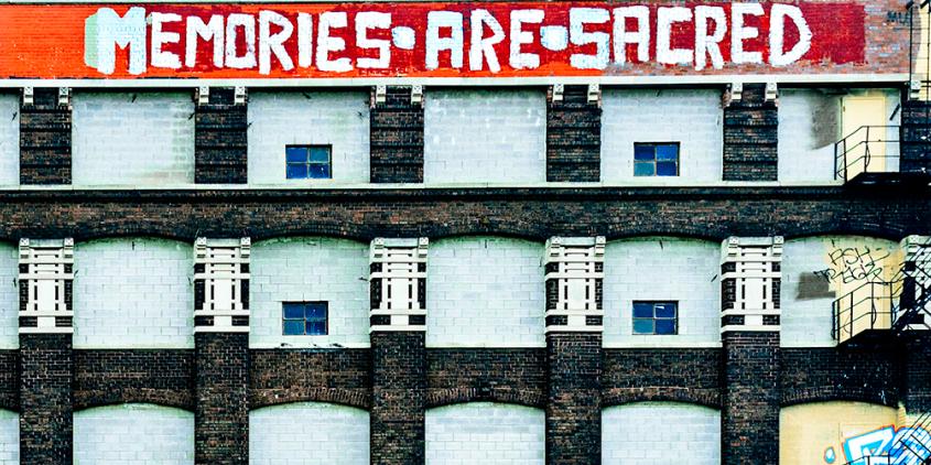 Riesige Häuserfassade. Ganz oben ein Graffiti: "Memories are sacred".