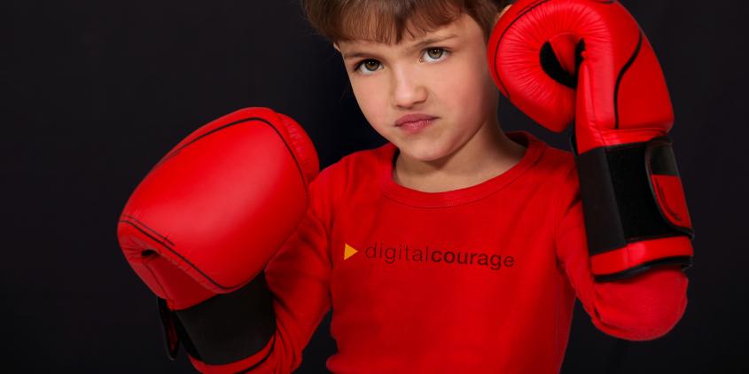 Ein Kind mit Boxhandschuhen.