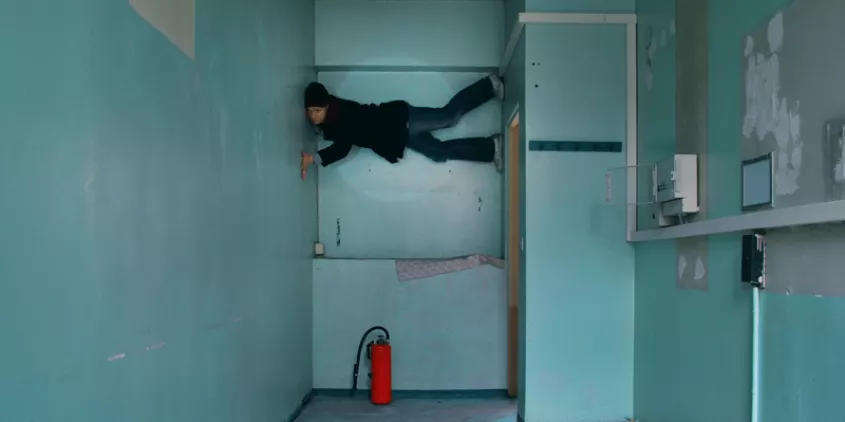 Eine Person, die zwischen zwei Wänden hochgeklettert ist.