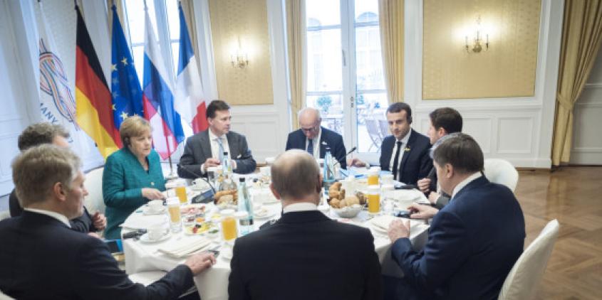 Mehrere Staatschef.innen an einem runden Tisch (u. a. Angela Merkel und Emmanuel Macron).