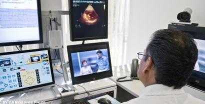 Ein Arzt der vor mehreren Bildschirmen sitzt, u.a. ist ein Ultraschall zu sehen.