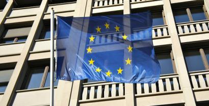 Die EU-Flagge weht vor einem Bürogebäude.