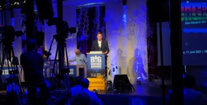 Im Vordergrunde Kameras, im Hintergrund Andreas Liebold, Moderator der Big Brother Awards an einem Rednerpult