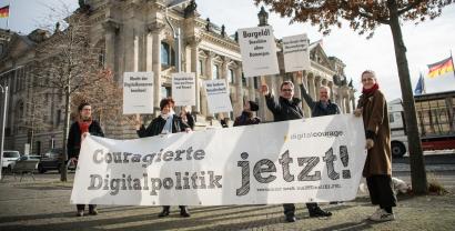 Aktive von Digitalcourage halten ein Banner mit de Überschrift "Couragierte Digitalpolitik - jetzt! Verdammt noch mal !!!eins elf!!"
