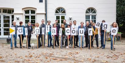 Teamfoto von Digitalcourage. Einzelne Mitglieder halten Schilder mit den Buchstaben von Digitalcourage hoch.