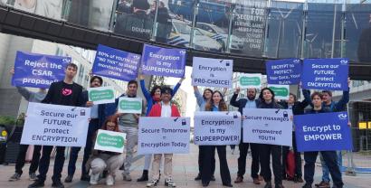 Menschen stehen vor dem Europäischen Parlament und halten Schilder für ein Recht auf Verschlüsselung hoch.