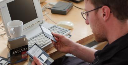 Ein Digitalcourage-Mitarbeiterschaut sich Disketten an.