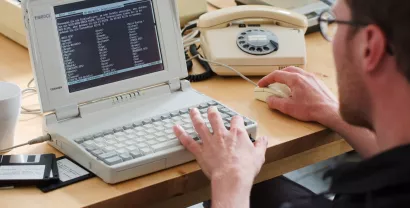 Ein Digitalcourage-Mitarbeiter vor einem alten PC.