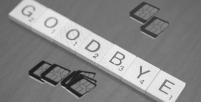 Schwarz-weiß-Bild: Das Wort "Goodbye" gelegt aus Spielsteinen. Drumherum liegen Sim-Karten.