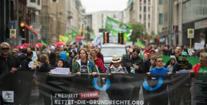 Demonstrant.innen mit einem riesigen „Rettet die Grundrechte“-Banner.