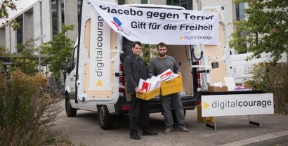 Aktionsstand von Digitalcourage mit einem Banner: „Placebo gegen Terror. Gift für die Freiheit.“