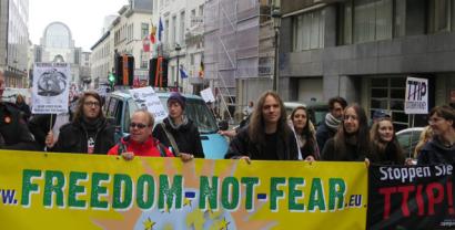 Demonstrant.innen mit einem Banner von "Freedom not Fear".