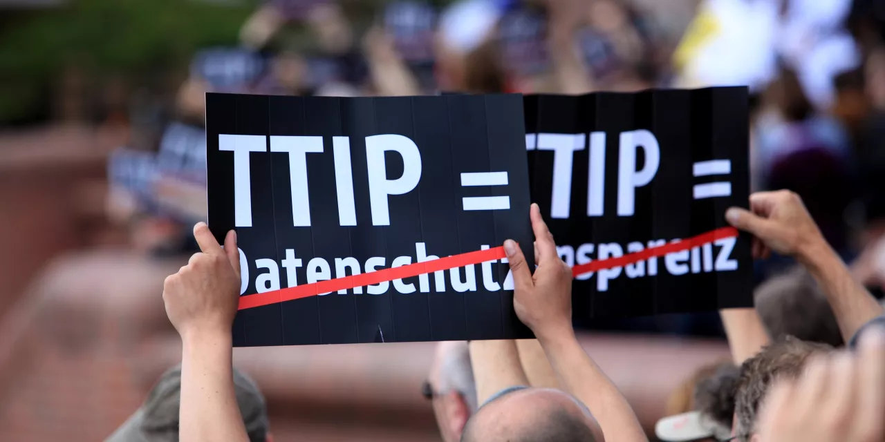 Ein Demoschild mit dem Text: "TTIP = Datenschutz" (Datenschutz ist durchgestrichen).