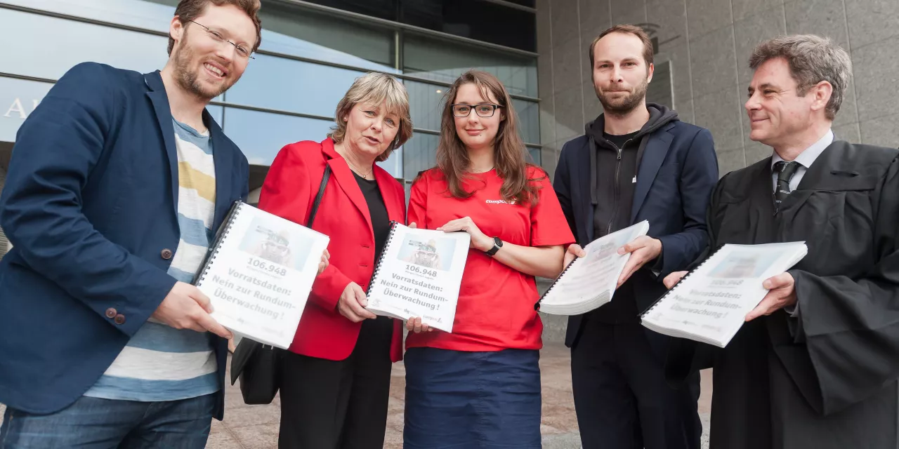 Mehrere Personen mit gesammelten Unterschriften als Ringbuch.