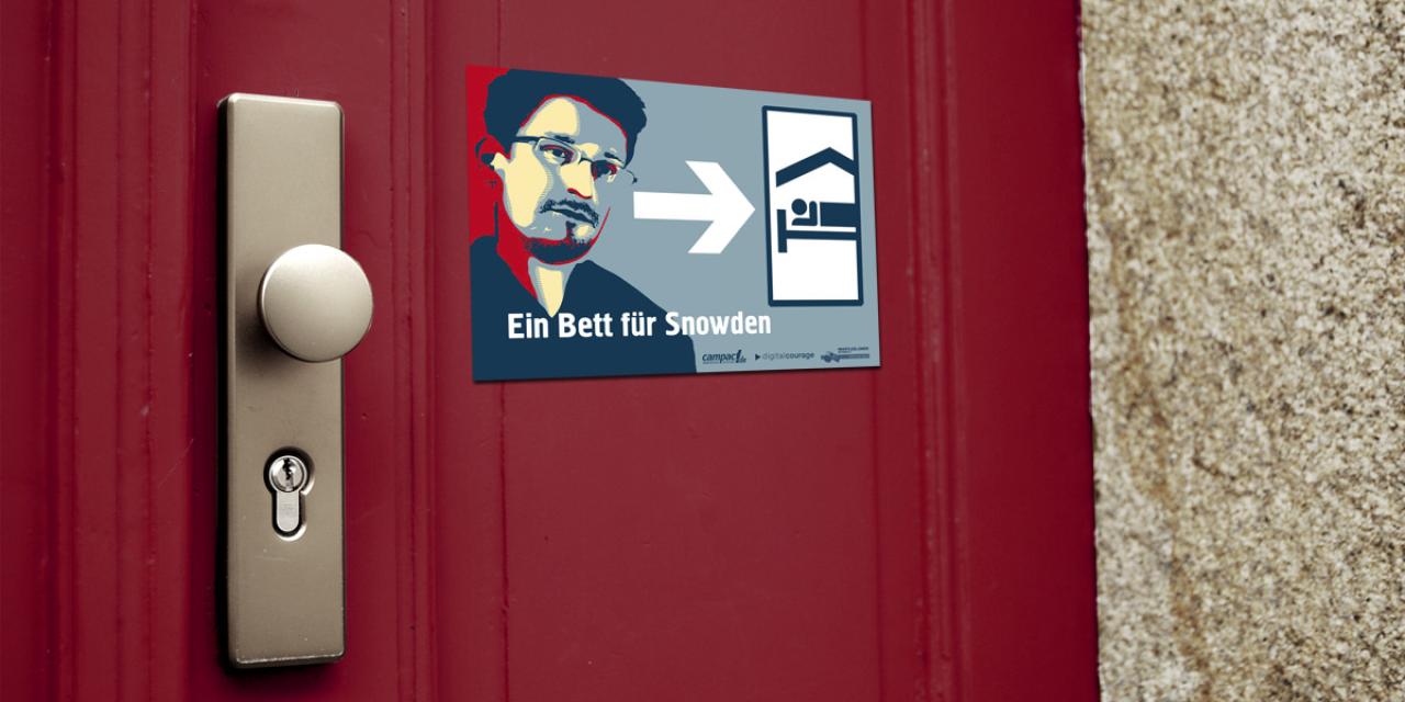 Eine rote Tür mit Türknauf. Daneben ein Aufkleber „Ein Bett für Snowden“.