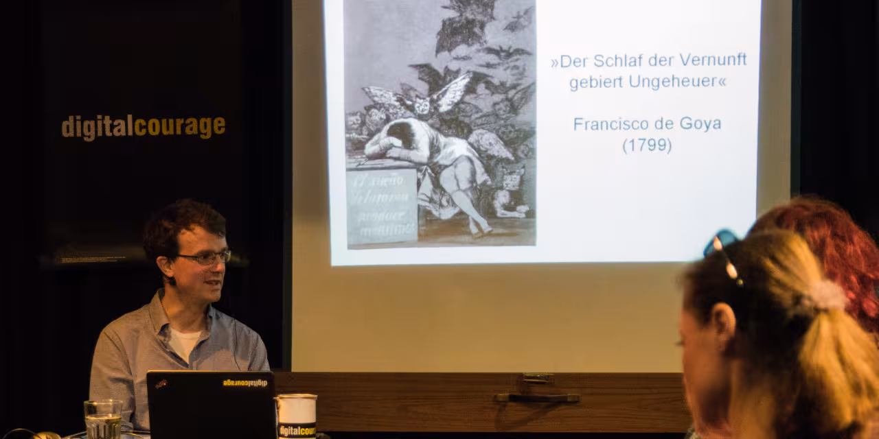 Sprecher und Beamerbild während einer PD-Veranstaltung.