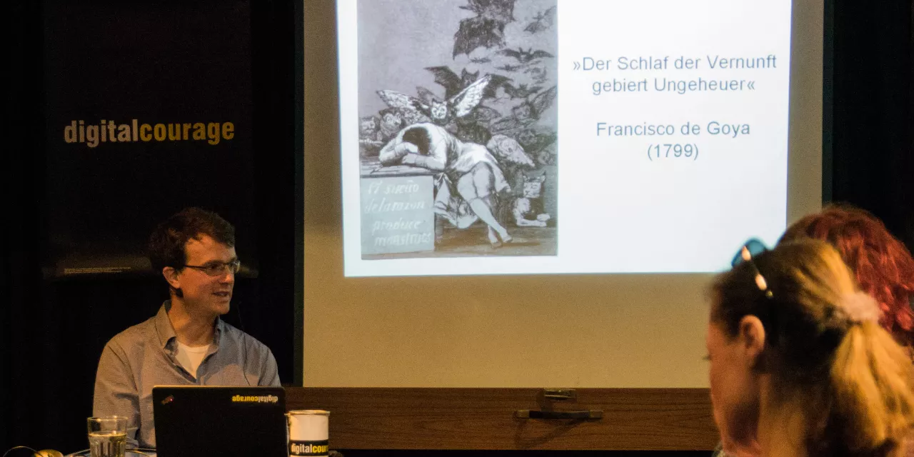 Sprecher und Beamerbild während einer PD-Veranstaltung.