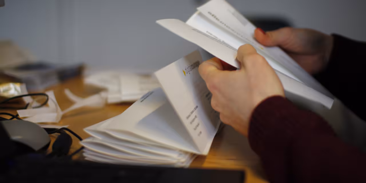 Detailaufnahme: Hände, die einen Brief auseinander falten.