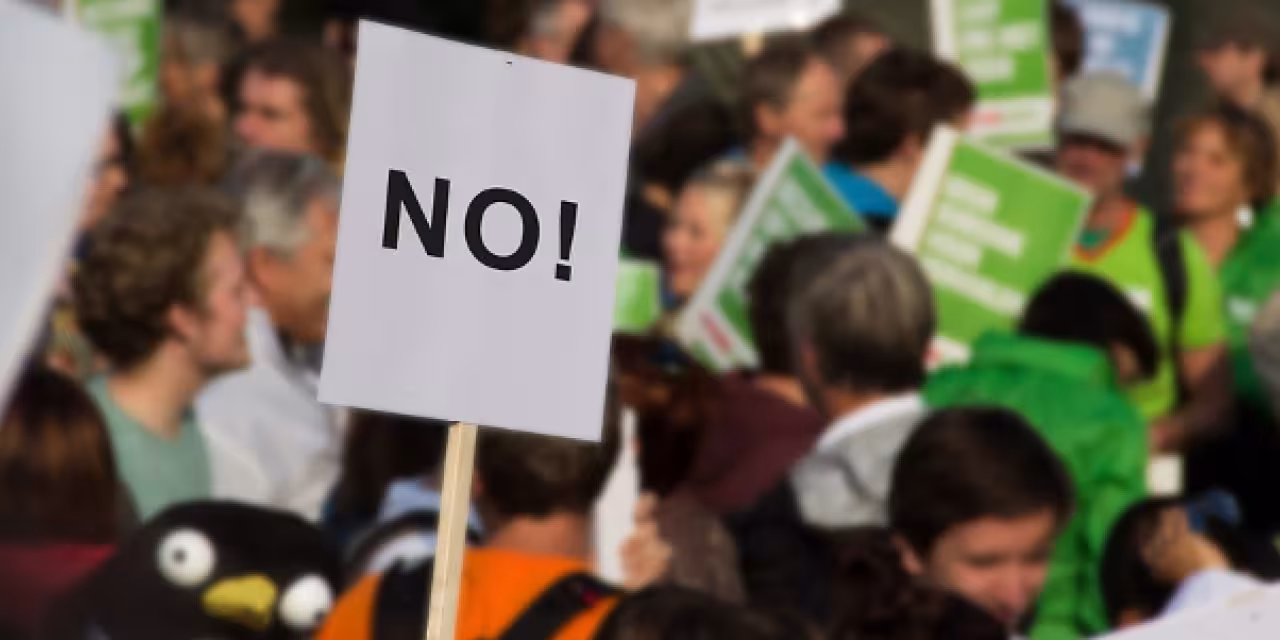 Menschen auf einer Demonstration. Ein Schild, auf dem „No“ steht.
