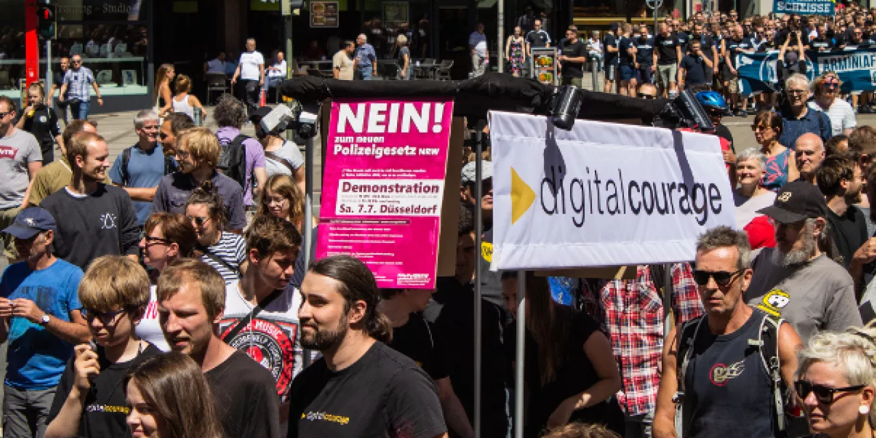 Aktivist.innen mit diversen Bannern auf einer Demo.