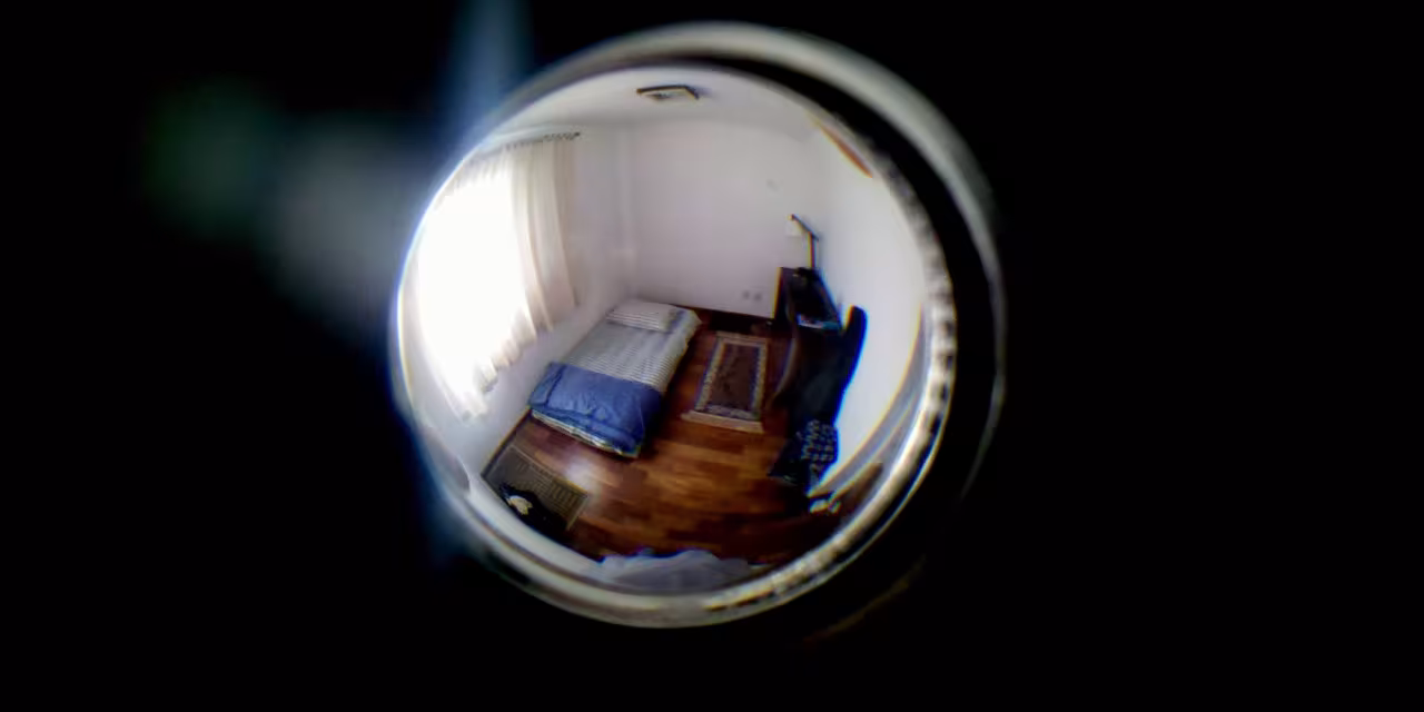 Blick durch eine Linse, dahinter ein Raum in Fisheye-Optik.