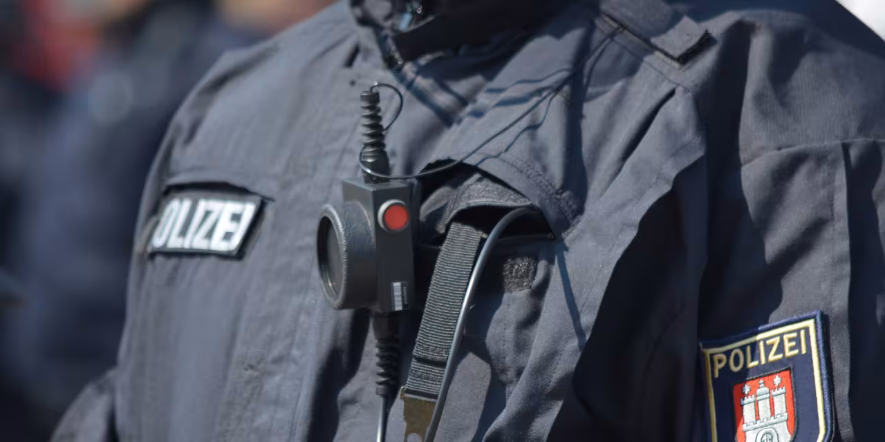 Detailaufnahme des Brustbereichs eines.einer Polizist.in, im Fokus die Aufnäher der Polzei.