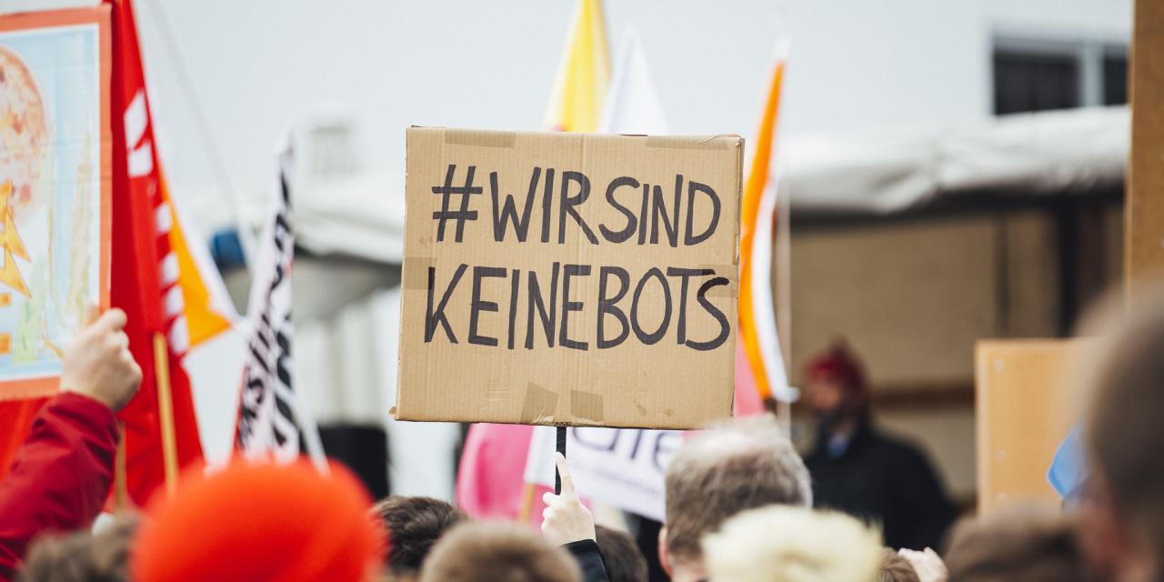 Ein Demoschild mit der Aufschrift: „Wir sind keine Bots“.