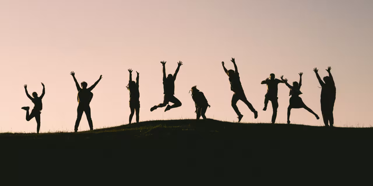 Silhouette von mehrere Menschen, die in die Luft springen.