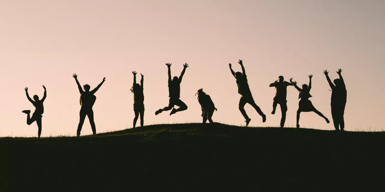 Silhouette von mehrere Menschen, die in die Luft springen.