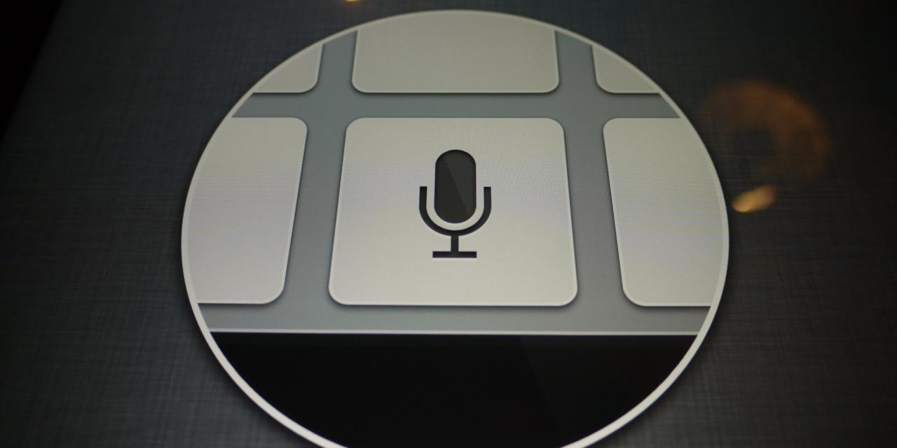 Ein abfotografierter Bildschirm. Darauf eine Grafik die einen großen Kreis abbildet, darin weiße Kacheln und in einer Kachel ein schwarzes Mikrofon.