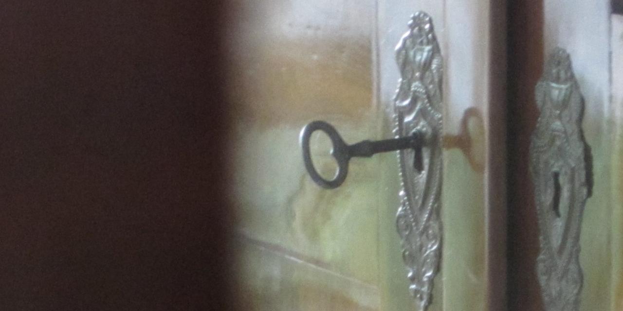 Ein alter Schlüssel in einem Schlüsselloch einer alten Tür.