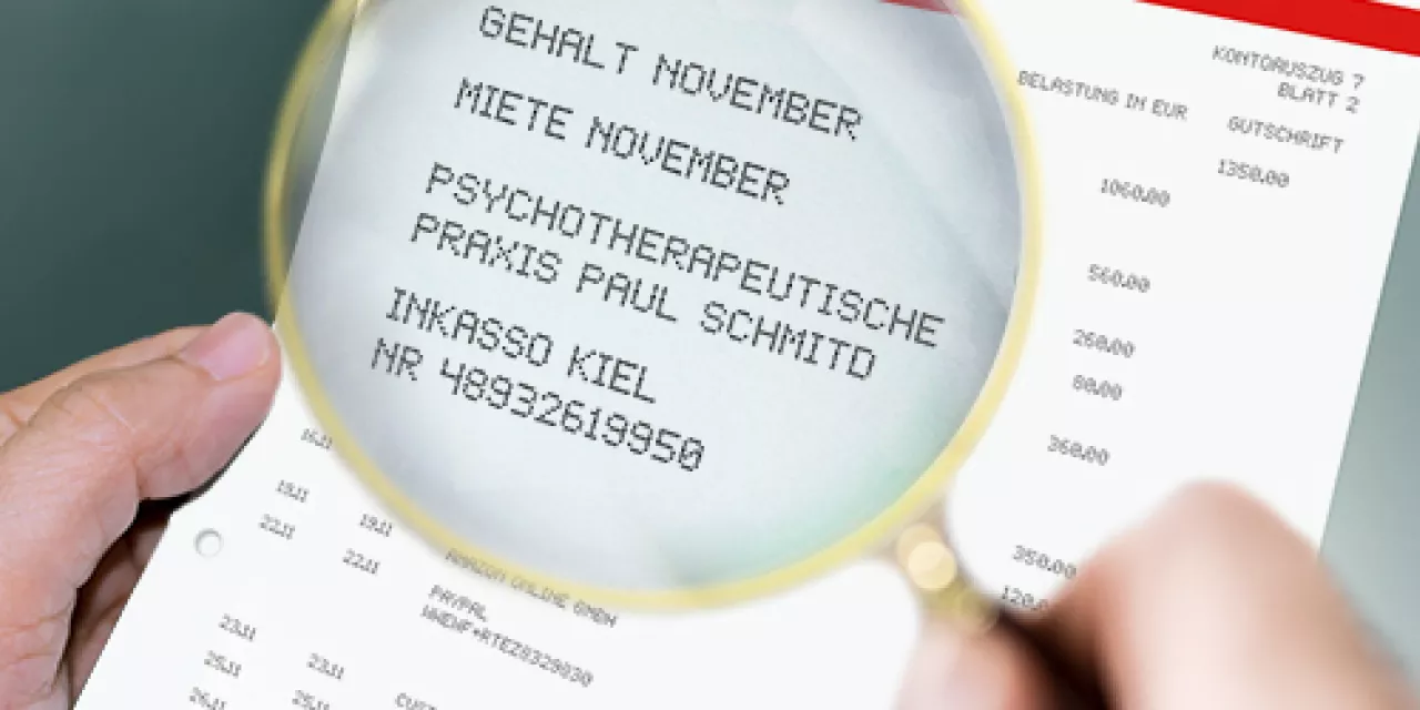 Eine Lupe, die den Text auf einem Kontoauszug vergrößert darstellt.