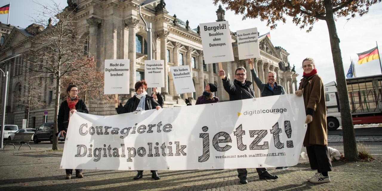 Aktive von Digitalcourage halten ein Banner mit de Überschrift "Couragierte Digitalpolitik - jetzt! Verdammt noch mal !!!eins elf!!"