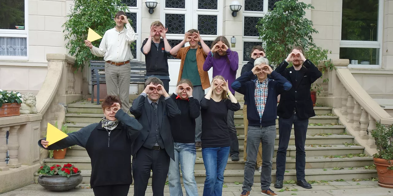 Das Team von Digitalcourage auf einer Treppe und bei der symbolischen Suche.