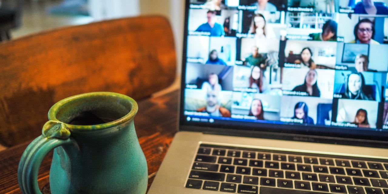 Foto eines Laptops mit vielen Personen, die an einer Videokonferenz teilnehmen.