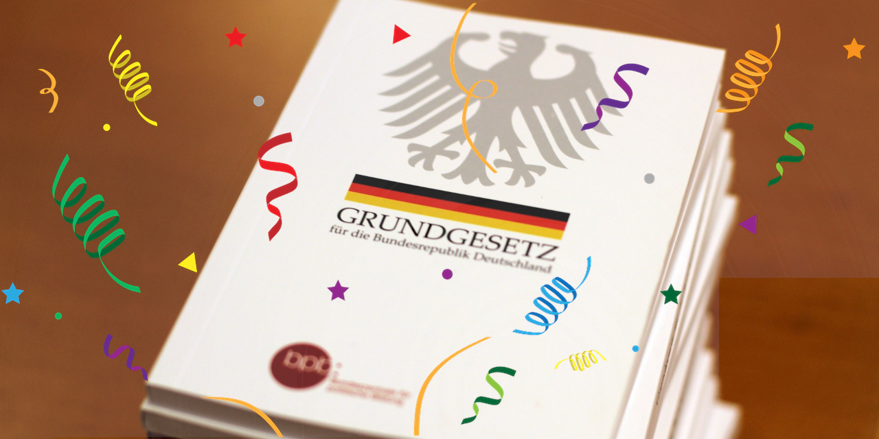 Ein stapel Grundgesetze mit Konfettigrafiken