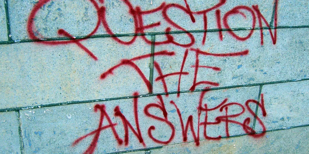 Beschmierte Wand mit dem Satz "Question the answers".