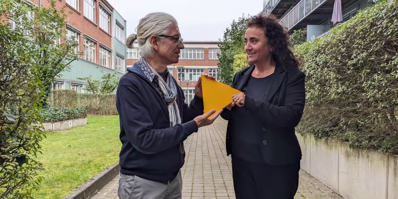 Detlev Sieber übergibt Naciye Demirbilek das gelbe Digitalcourage-Dreieck