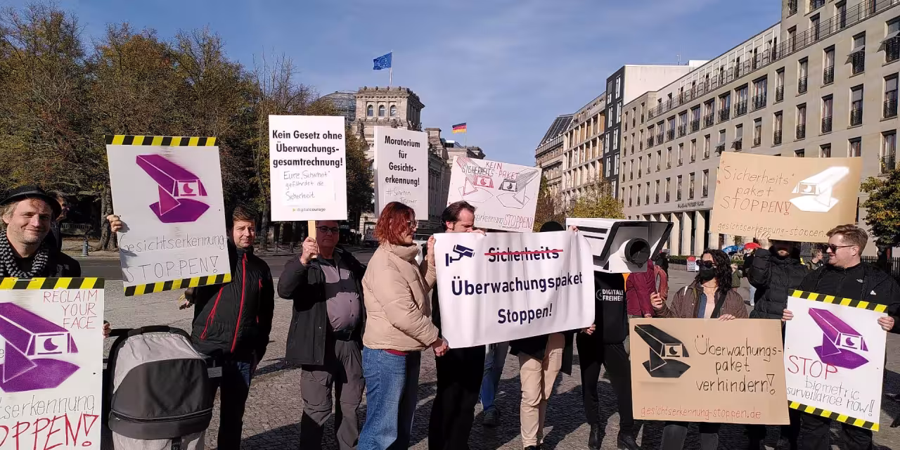 Leute mit Schildern und Transparenten demostrieren gegen das Sicherheitspaket.