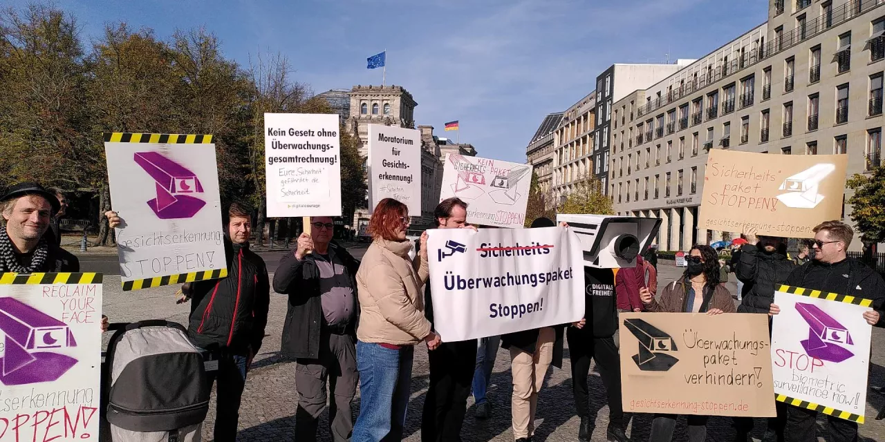 Leute mit Schildern und Transparenten demostrieren gegen das Sicherheitspaket.