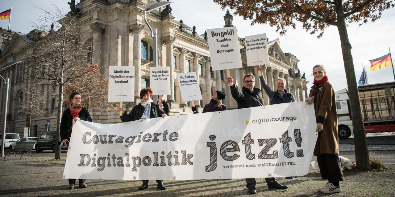 Menschen mit einem Banner „Couragierte Digitalpolitik jetzt!“ vor dem Deutschen Bundestag.