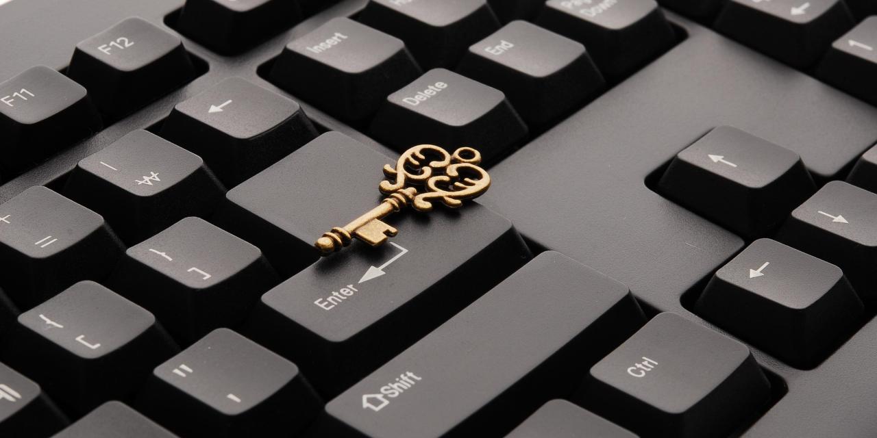 Ausschnitt einer schwarzen Tastatur. Darauf liegend ein goldener Schlüssel.